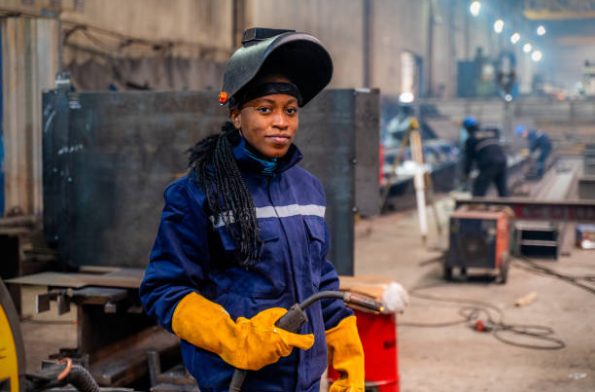 A young university student female is practicing her welding skills